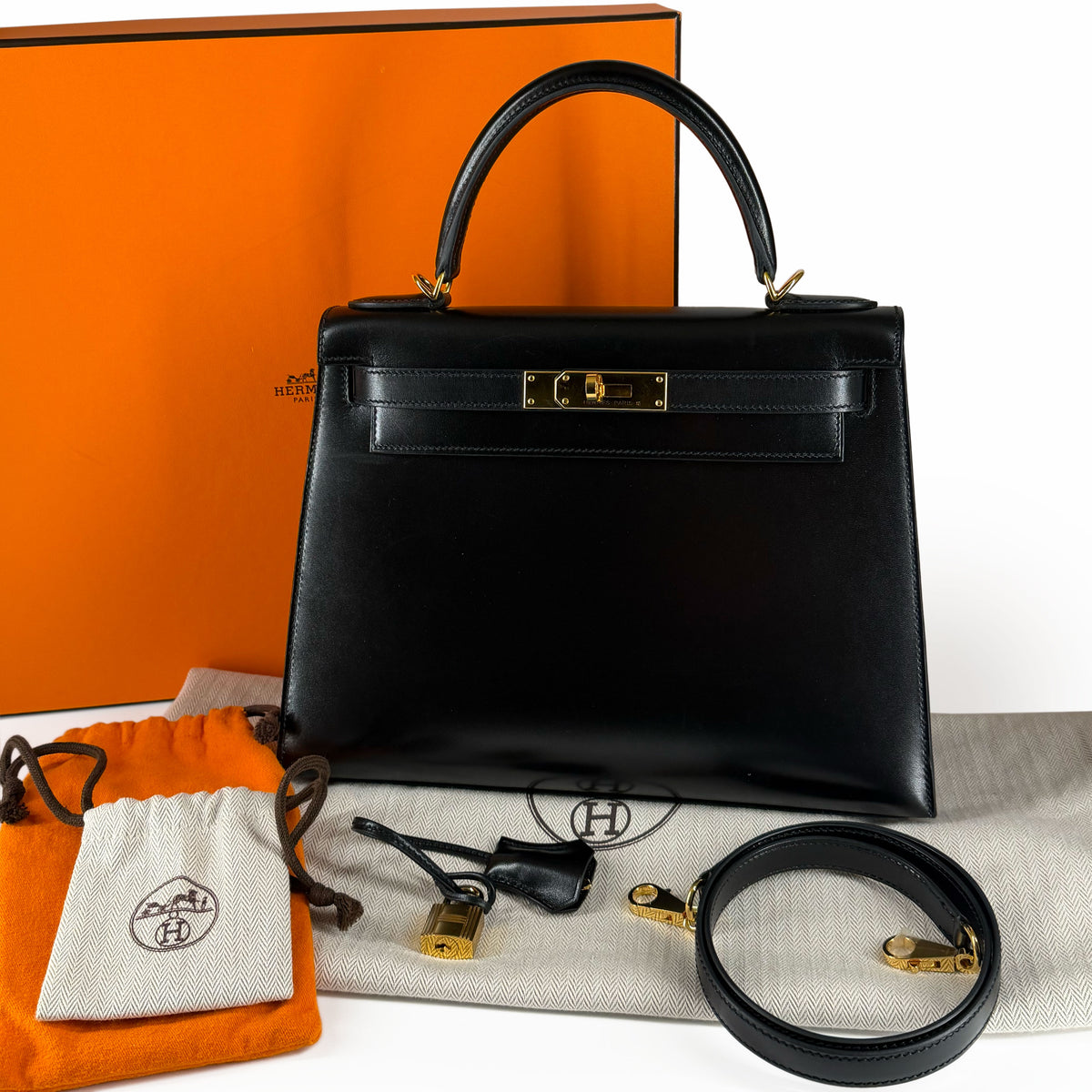 Black leather Hermès Kelly handbag with gold hardware and accessories, curated Pre-loved Luxury by Myluxe in Helsinki.