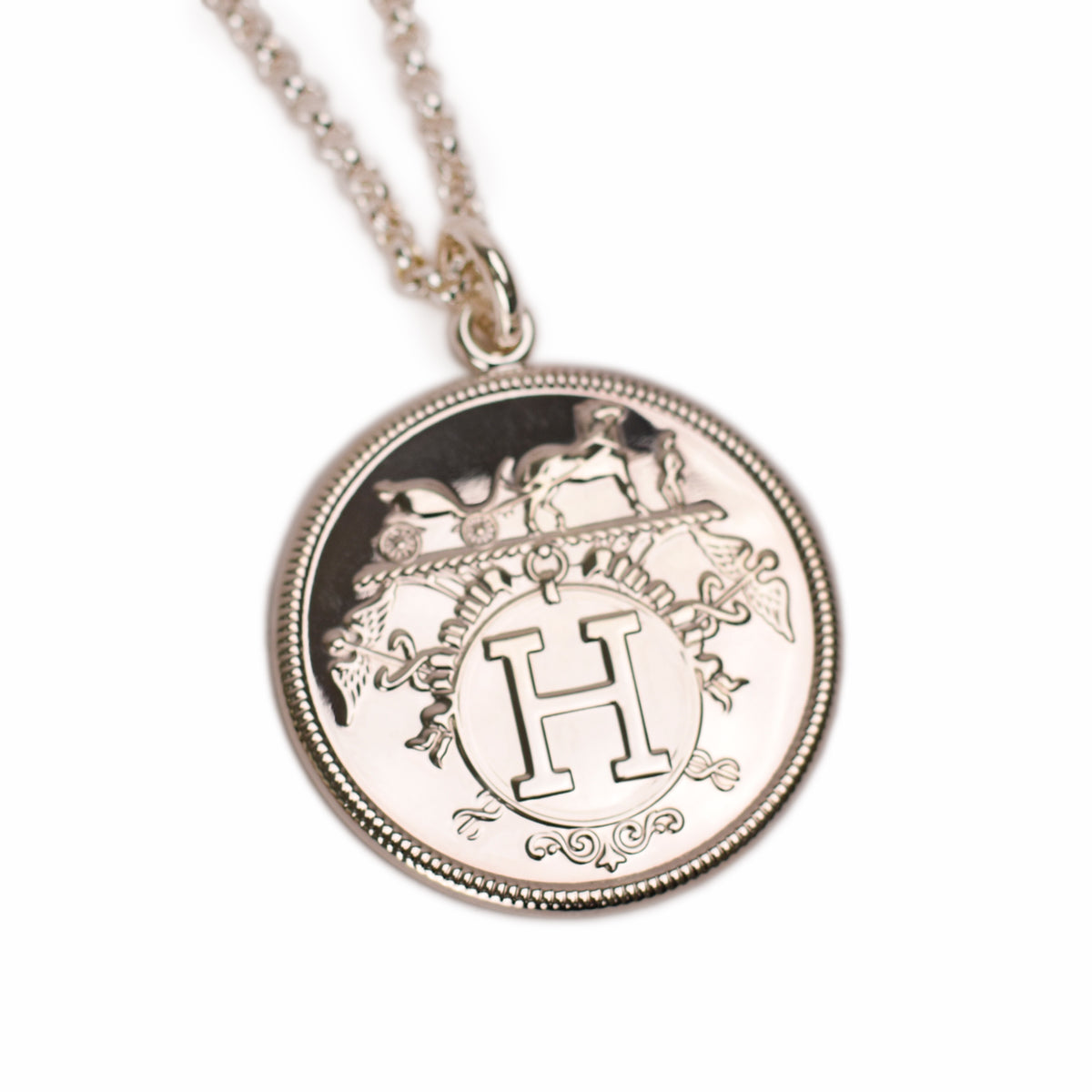 Silver Hermès medallion pendant with engraved logo. curated Pre-loved Luxury by Myluxe in Helsinki.