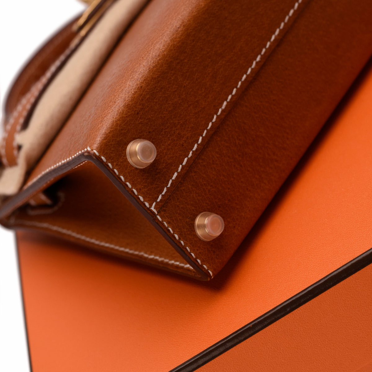 Close-up of brown leather handbag corner with gold-tone metal feet, curated Pre-loved Luxury by Myluxe in Helsinki.