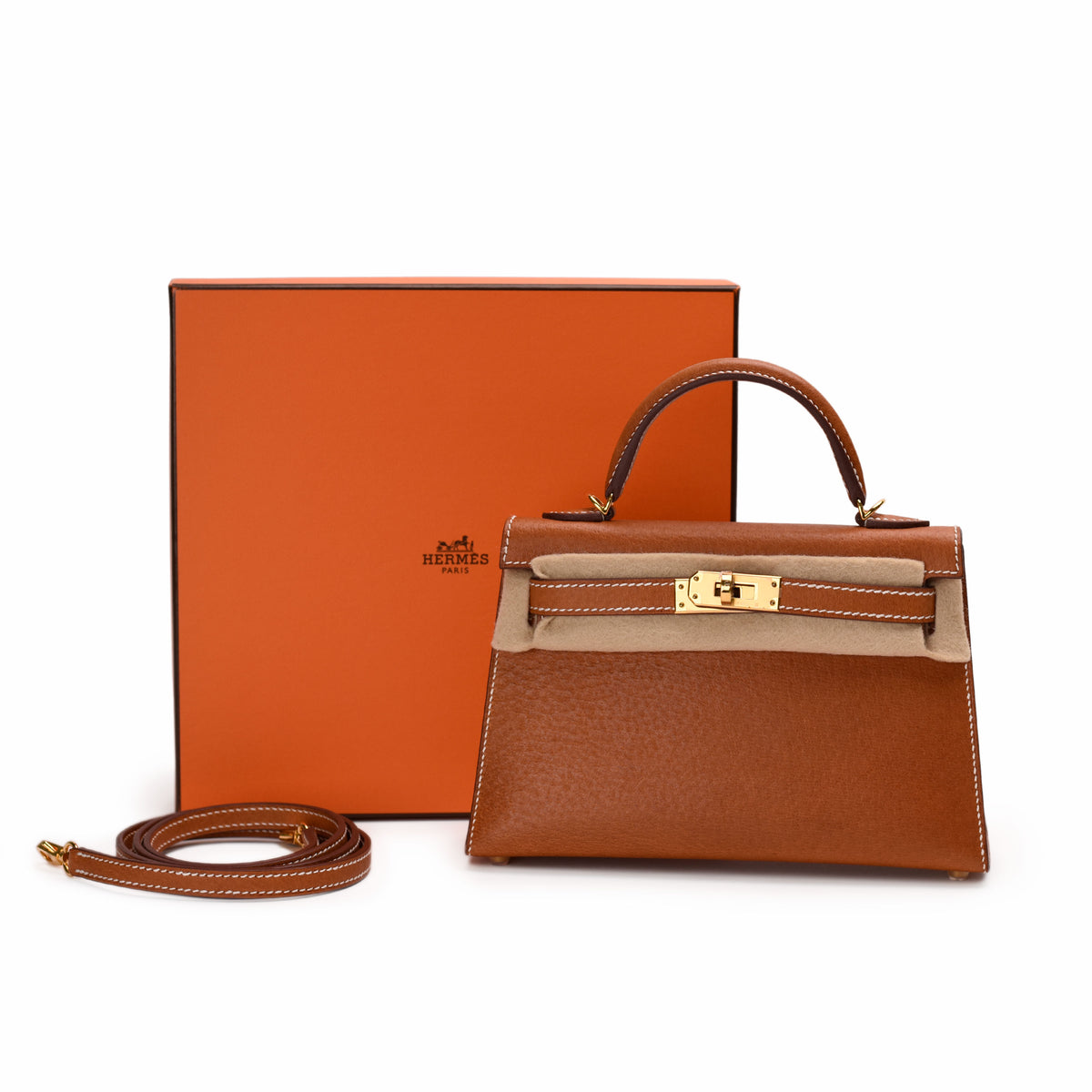 Brown leather Hermès handbag with gold hardware and matching strap, curated Pre-loved Luxury by Myluxe in Helsinki.