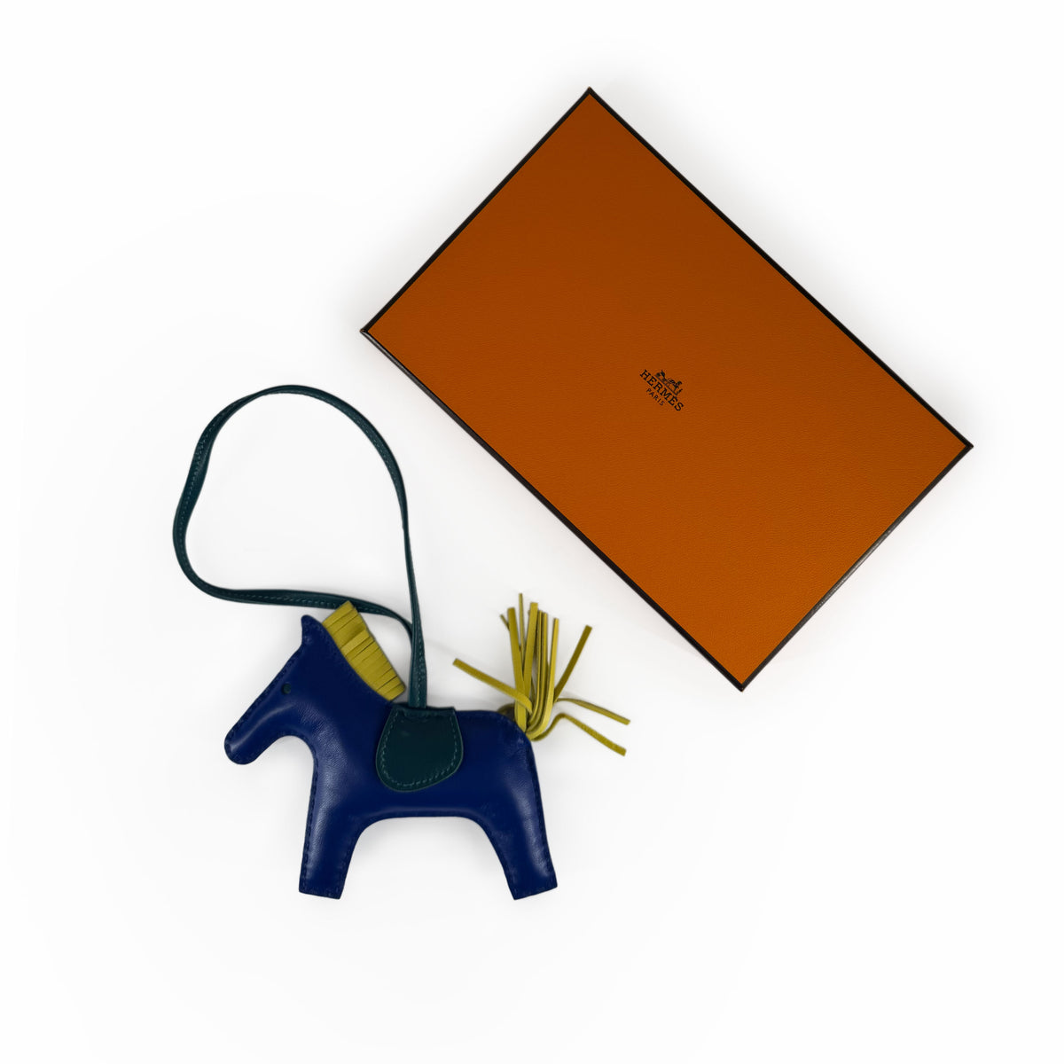 Blue leather Hermès horse charm with yellow tassel, curated Pre-loved Luxury by Myluxe in Helsinki.