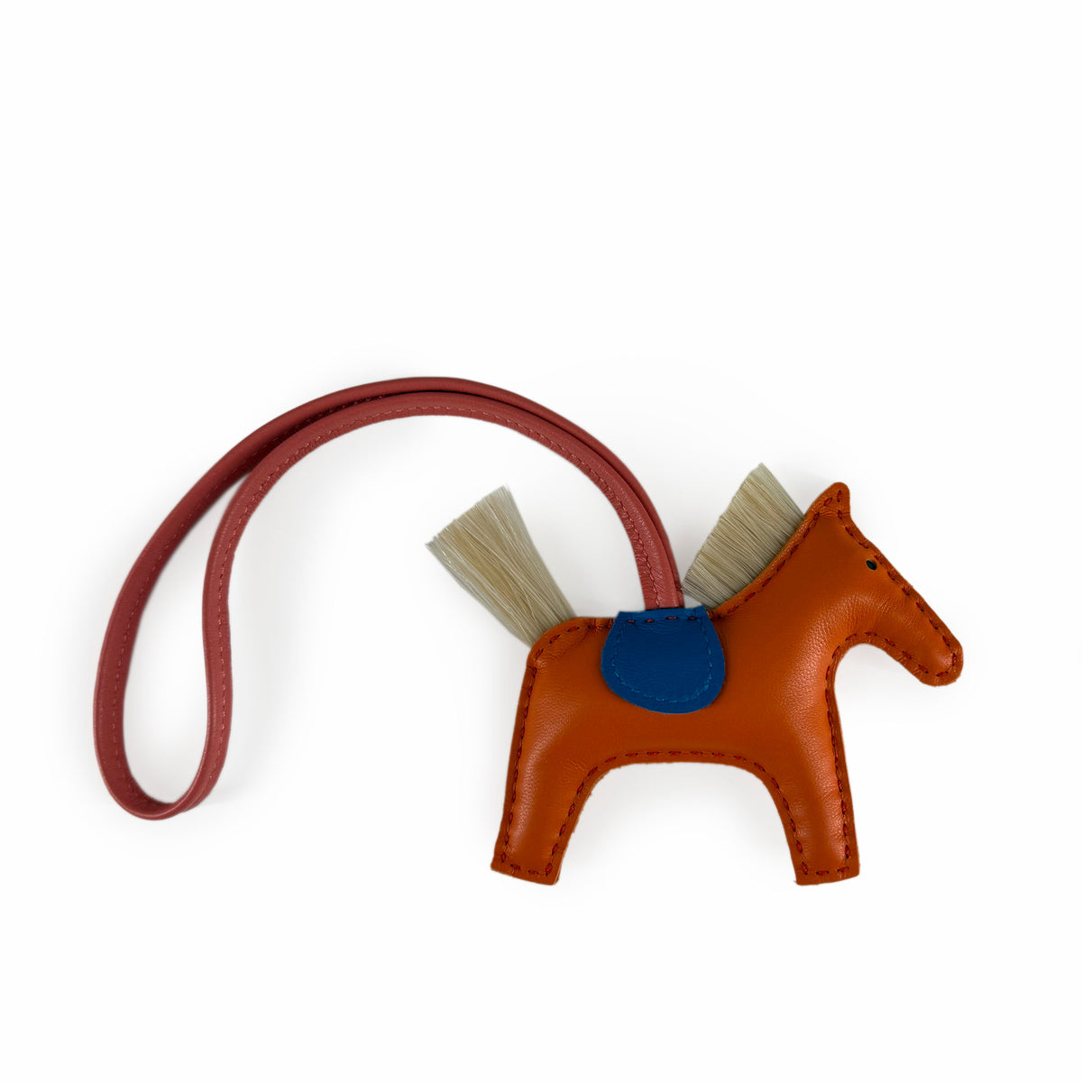 Orange leather horse-shaped charm with a blue accent and tan hair detail, curated Pre-loved Luxury by Myluxe in Helsinki.