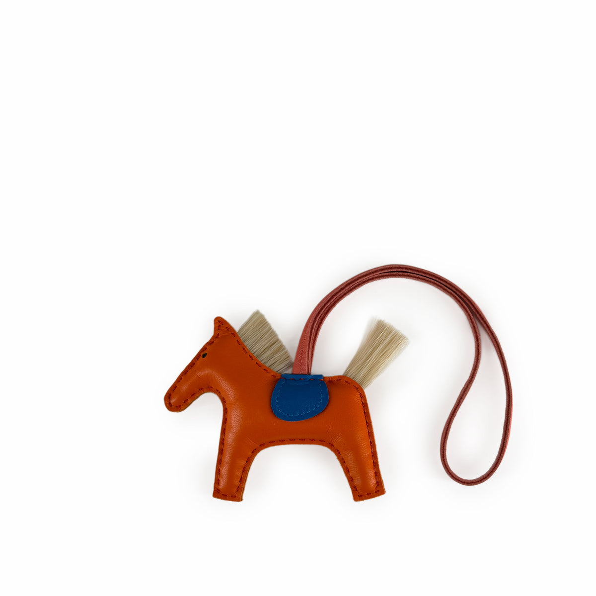 Orange leather horse charm with tan hair details, curated Pre-loved Luxury by Myluxe in Helsinki.