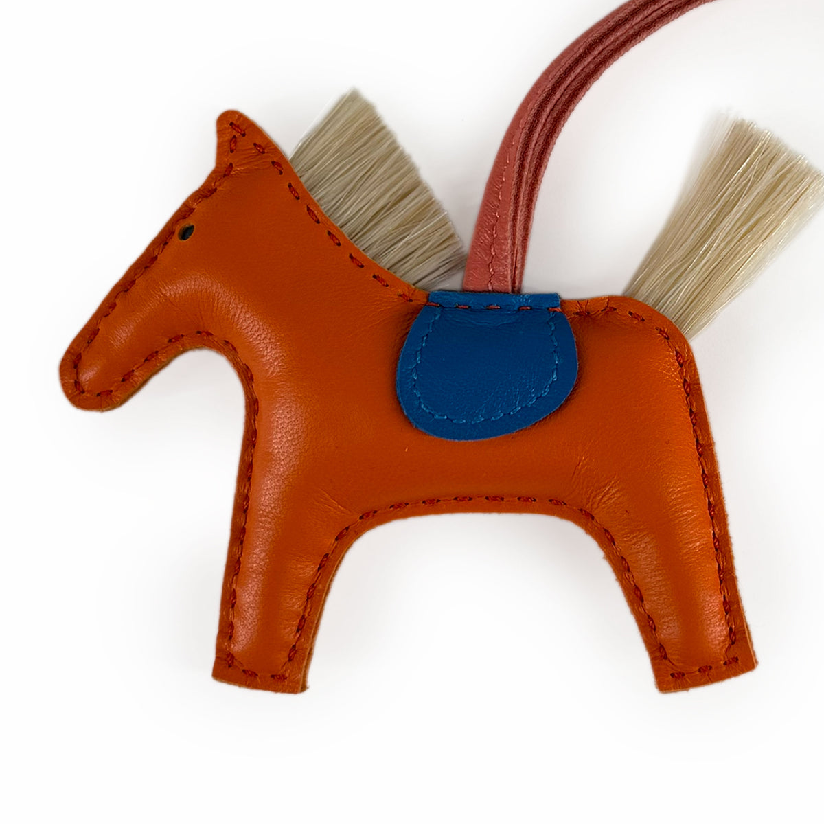 Orange leather horse keychain with blue saddle and natural hair details, curated Pre-loved Luxury by Myluxe in Helsinki.