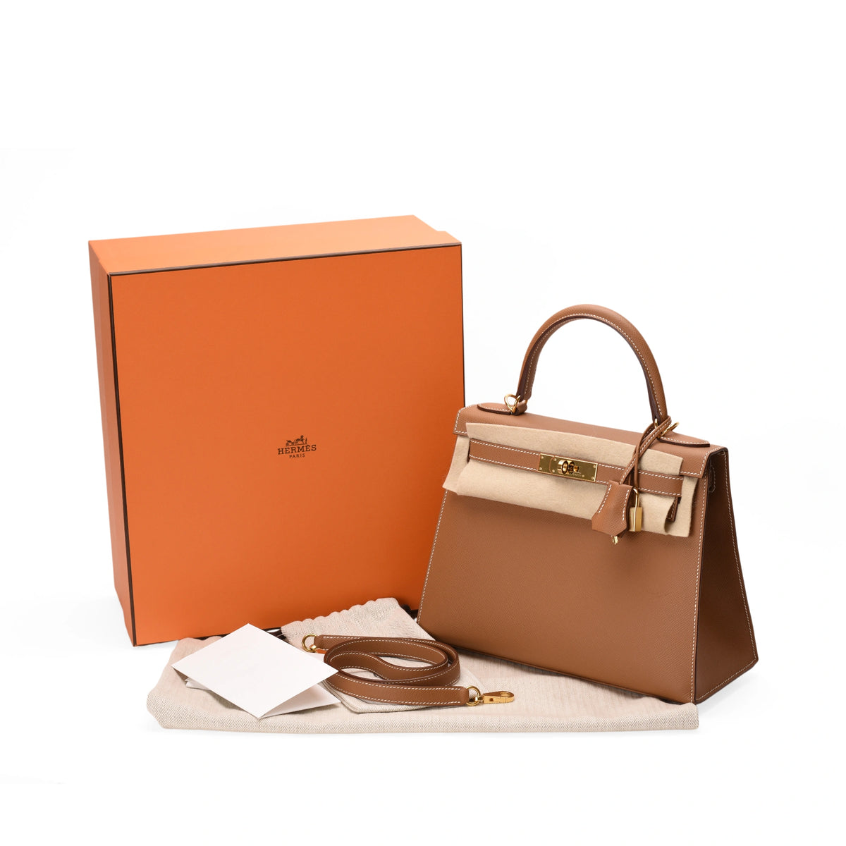 Hermès brown leather handbag with gold hardware and orange box. curated Pre-loved Luxury by Myluxe in Helsinki.