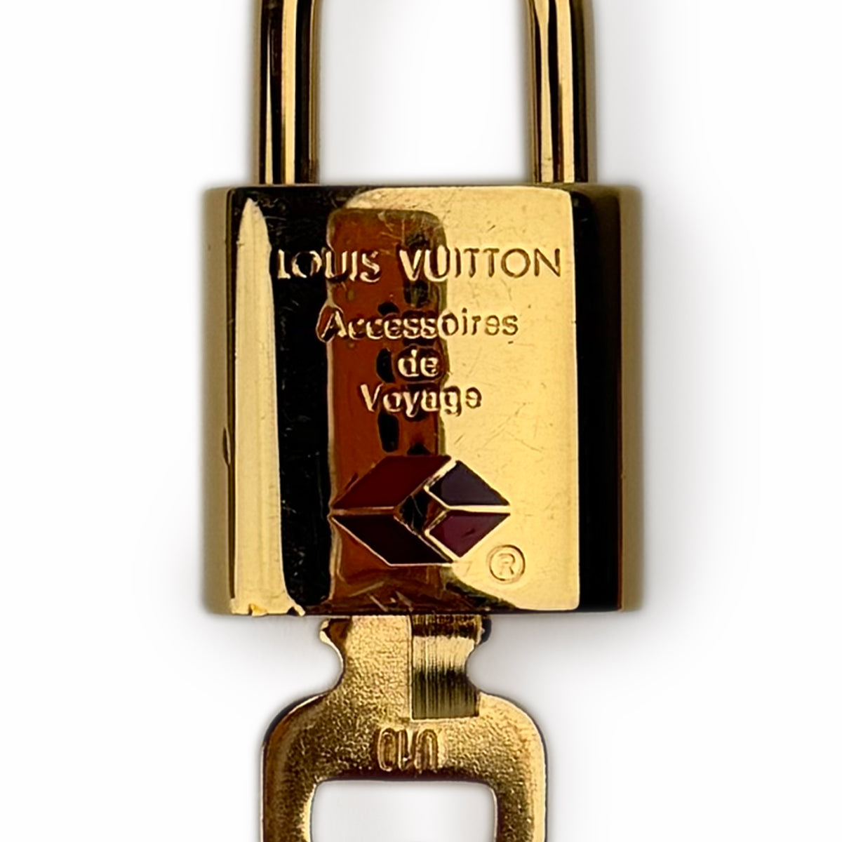 Gold-toned Louis Vuitton padlock with engraved text and logo, curated Pre-loved Luxury by Myluxe in Helsinki.