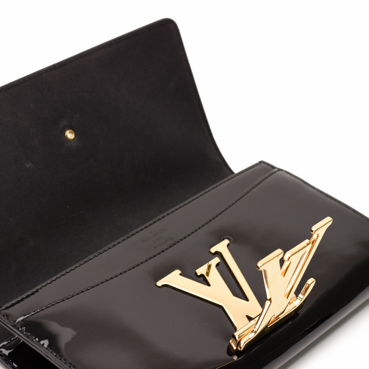 Black patent leather Louis Vuitton handbag with gold-tone LV logo clasp, curated Pre-loved Luxury by Myluxe in Helsinki.