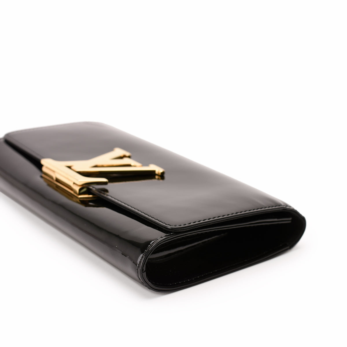 Black patent leather Louis Vuitton clutch with gold-tone LV hardware, curated Pre-loved Luxury by Myluxe in Helsinki.
