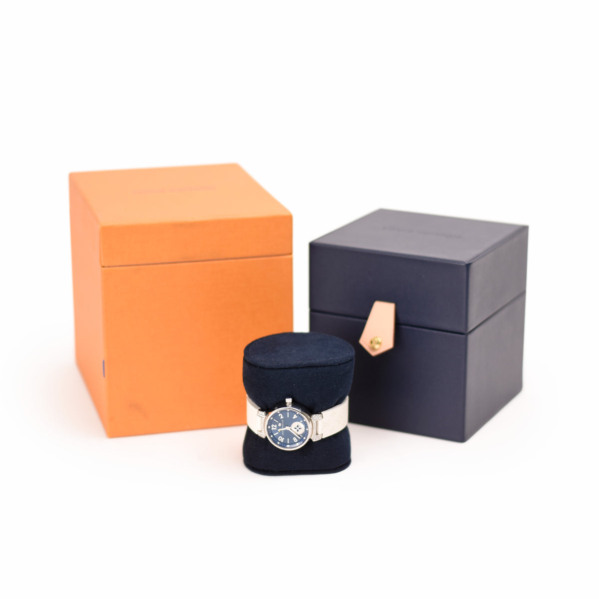 Hermès watch with blue dial and silver steel bracelet next to orange and black luxury boxes. curated Pre-loved Luxury by Myluxe in Helsinki.