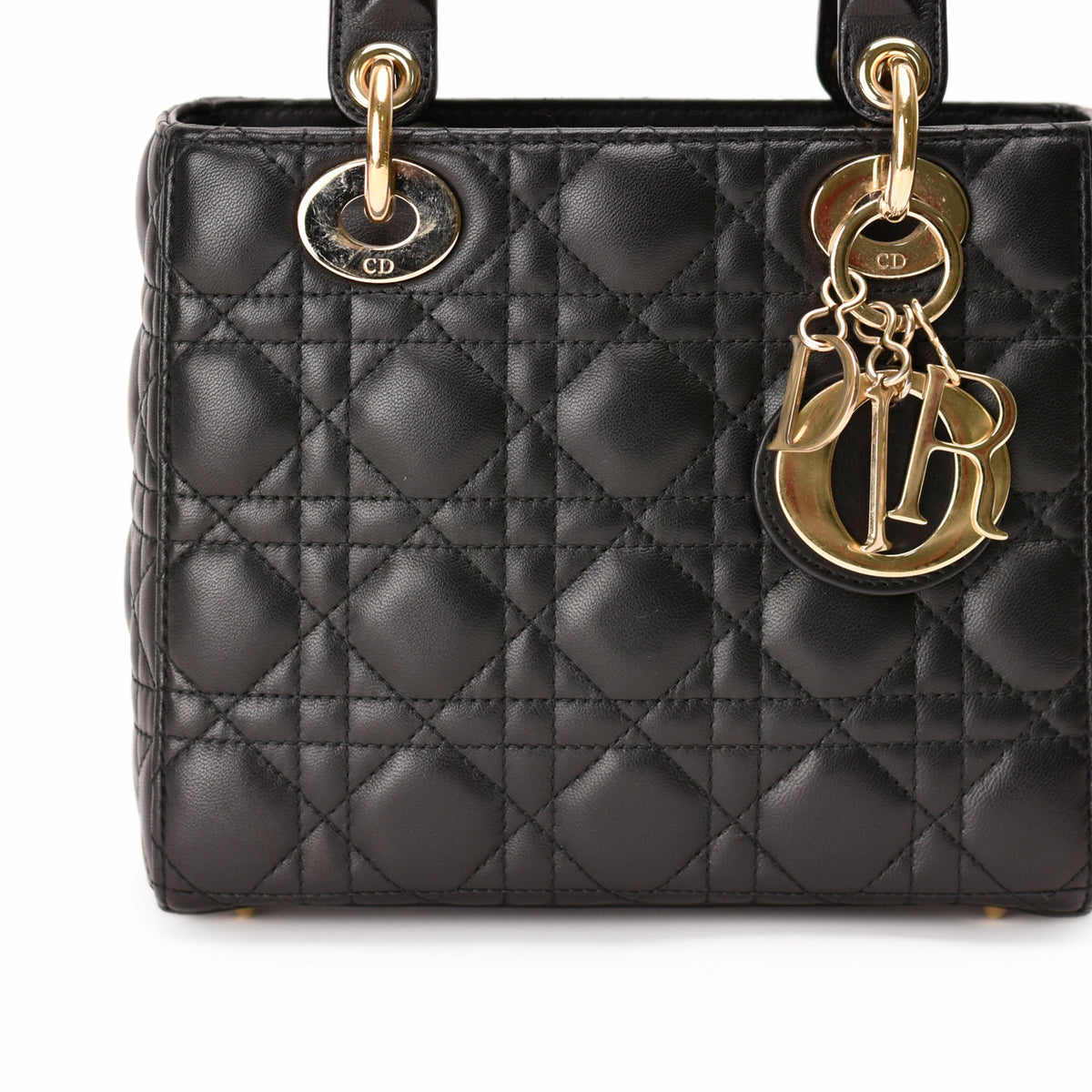 Black quilted leather Dior handbag with gold-tone charms, curated Pre-loved Luxury by Myluxe in Helsinki.
