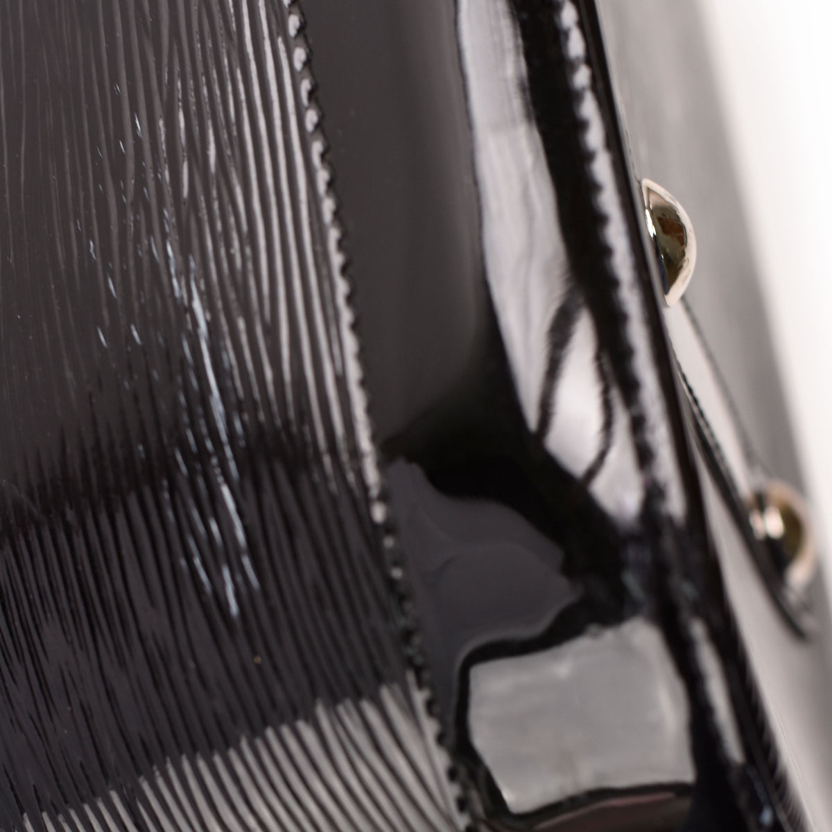 Close-up of black patent leather textured luxury handbag, curated Pre-loved Luxury by Myluxe in Helsinki.