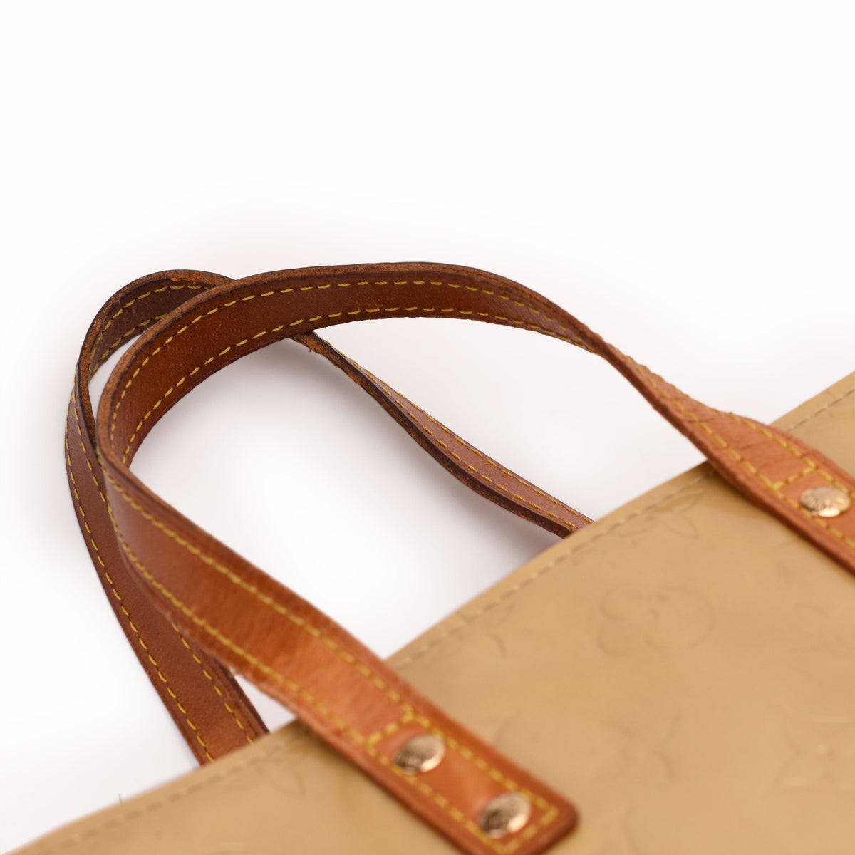 Tan leather handles of a Louis Vuitton monogram tote bag. curated Pre-loved Luxury by Myluxe in Helsinki.