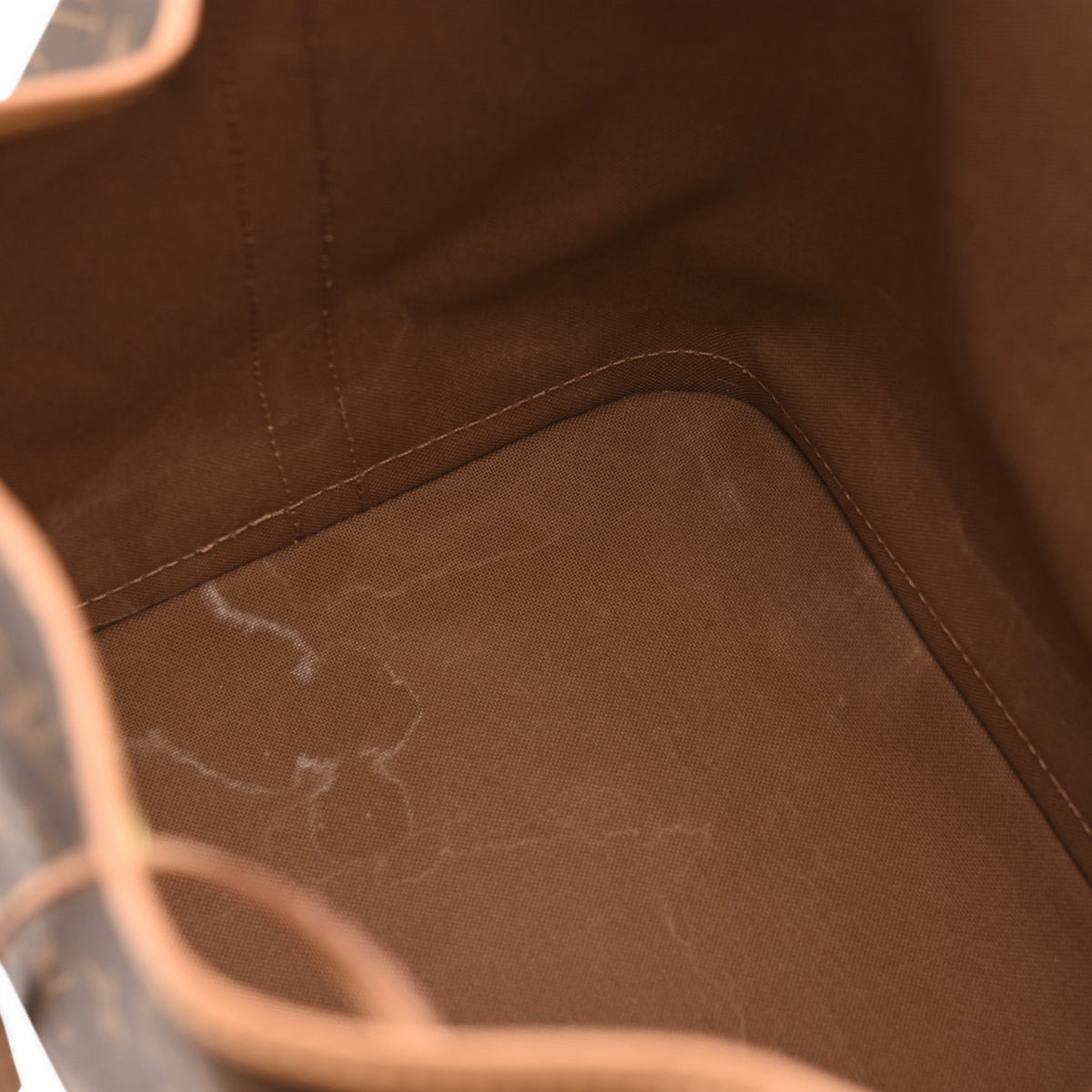 Interior of a brown canvas Louis Vuitton luxury handbag. curated Pre-loved Luxury by Myluxe in Helsinki.