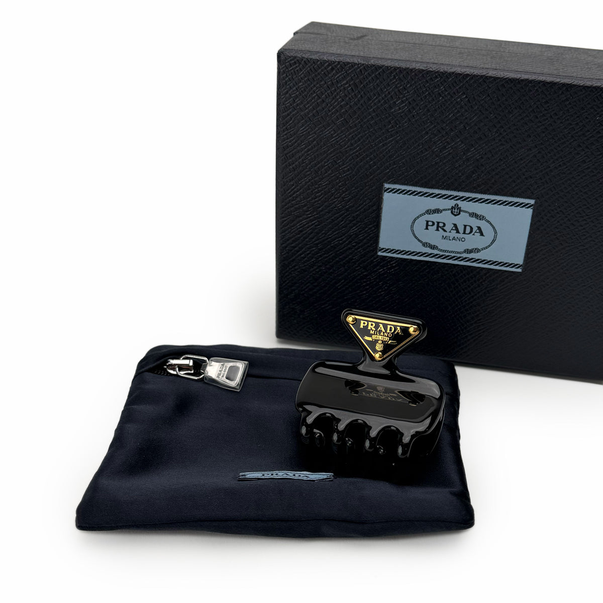 Black Prada Milano hair claw clip with gold logo detail, curated Pre-loved Luxury by Myluxe in Helsinki.