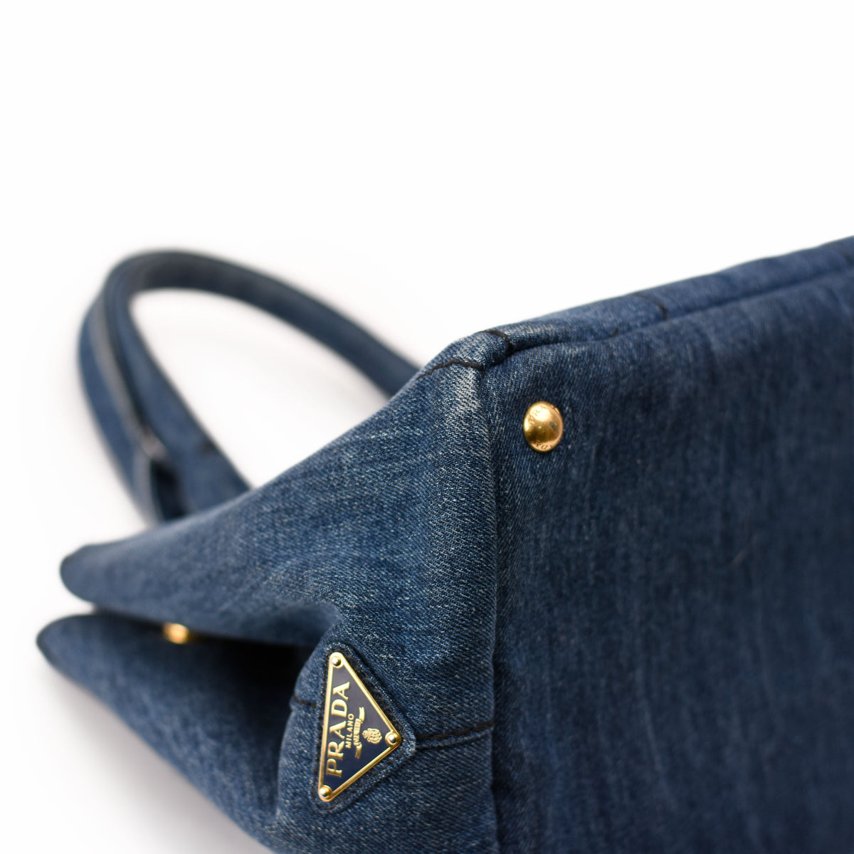 Prada blue denim handbag with gold-tone hardware. curated Pre-loved Luxury by Myluxe in Helsinki.