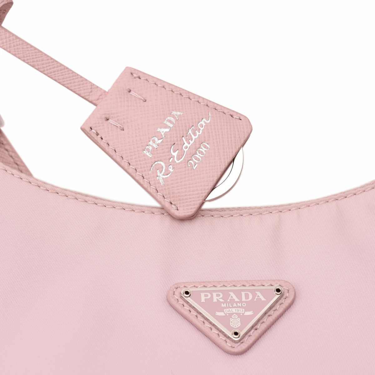 Pink Prada Re-Edition 2000 nylon handbag with silver triangle logo. curated Pre-loved Luxury by Myluxe in Helsinki.
