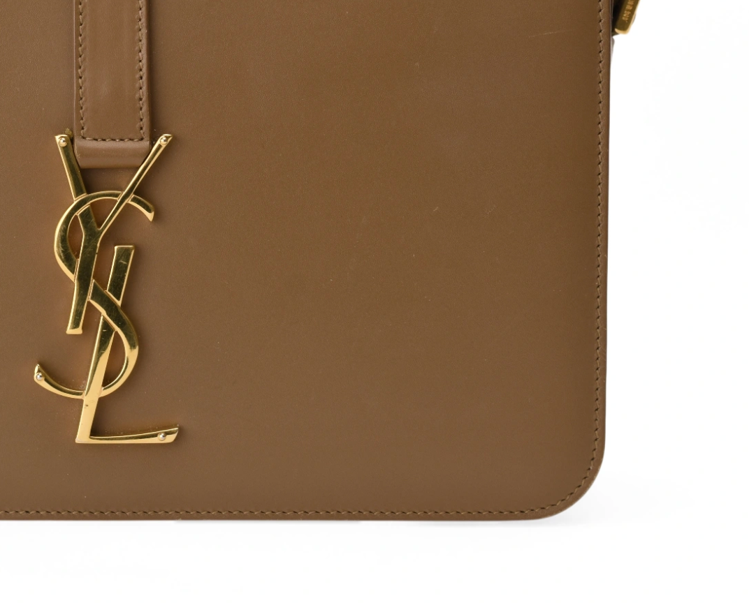 Brown leather Saint Laurent handbag with gold-tone YSL logo. curated Pre-loved Luxury by Myluxe in Helsinki.