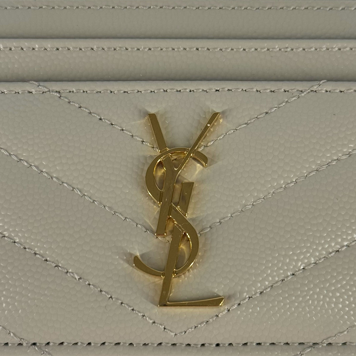 Gold-tone YSL logo on white pebbled leather, curated Pre-loved Luxury by Myluxe in Helsinki.