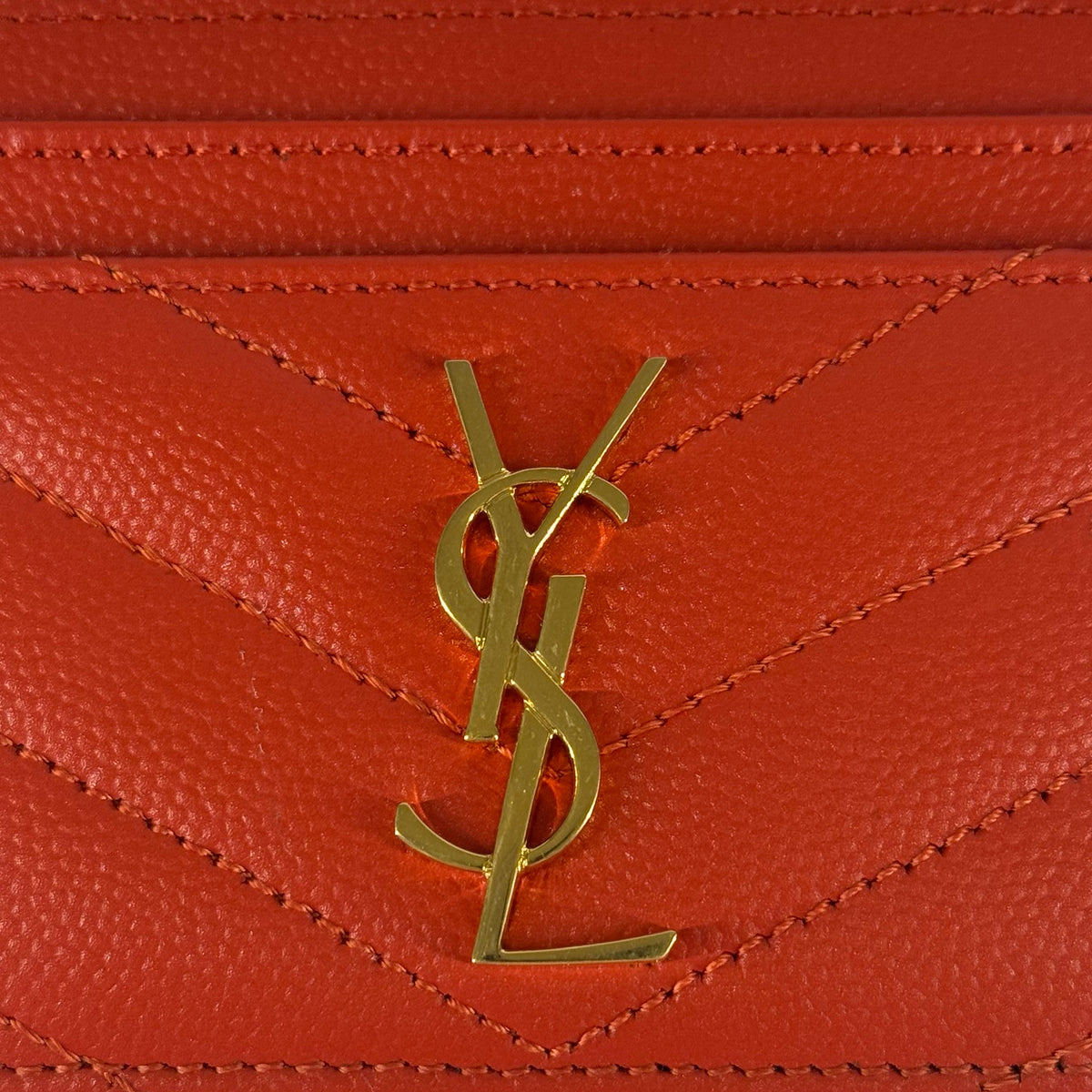 Gold-tone YSL logo on orange grained leather, curated Pre-loved Luxury by Myluxe in Helsinki.