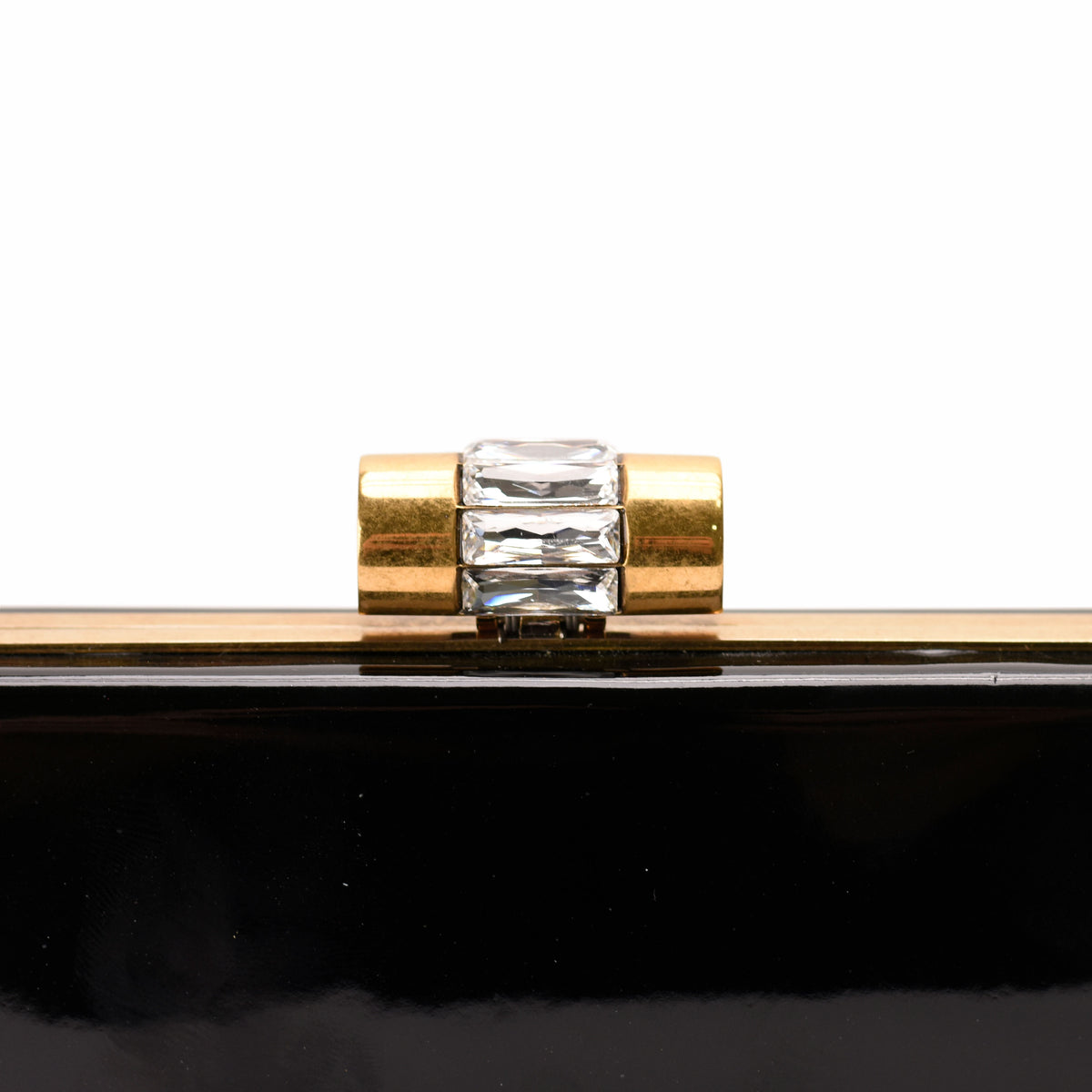Black patent leather clutch with a gold-tone clasp and crystal embellishment, curated Pre-loved Luxury by Myluxe in Helsinki.