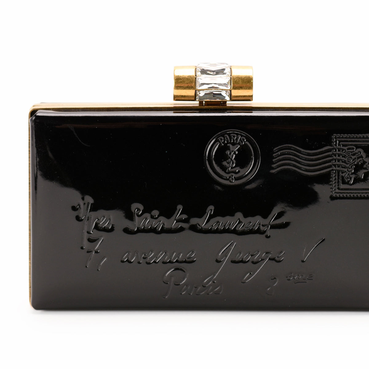 Black patent leather Saint Laurent clutch with gold hardware and embossed Parisian address, curated Pre-loved Luxury by Myluxe in Helsinki.