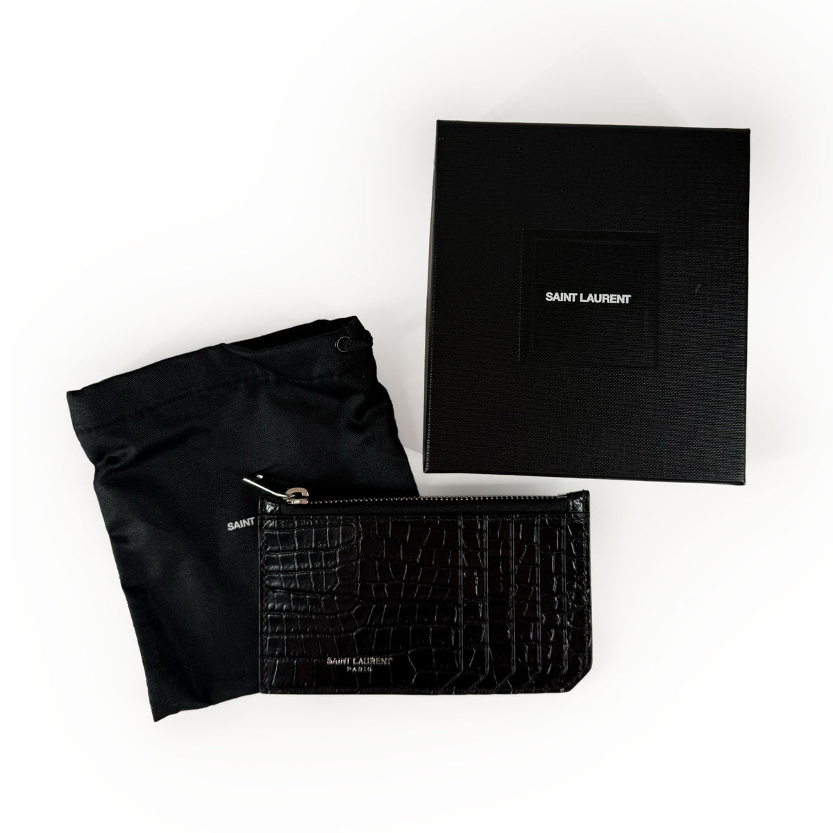 Black Saint Laurent crocodile-effect leather card holder with matching dust bag, curated Pre-loved Luxury by Myluxe in Helsinki.