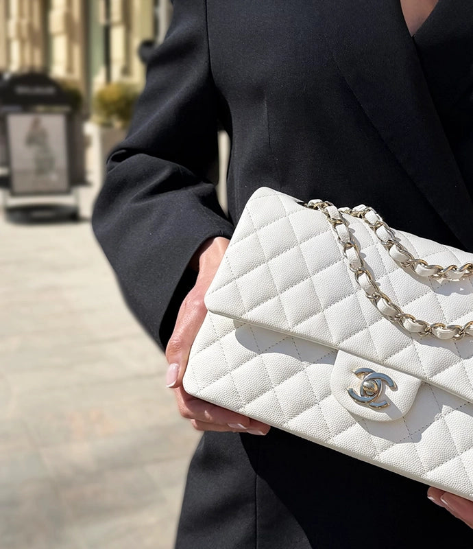 White quilted caviar leather Chanel handbag with gold-tone chain strap. Curated Pre-loved Luxury by Myluxe in Helsinki.
